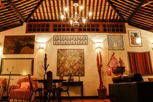 Una habitación acogedora con techo alto, una araña y varias obras de arte en las paredes.