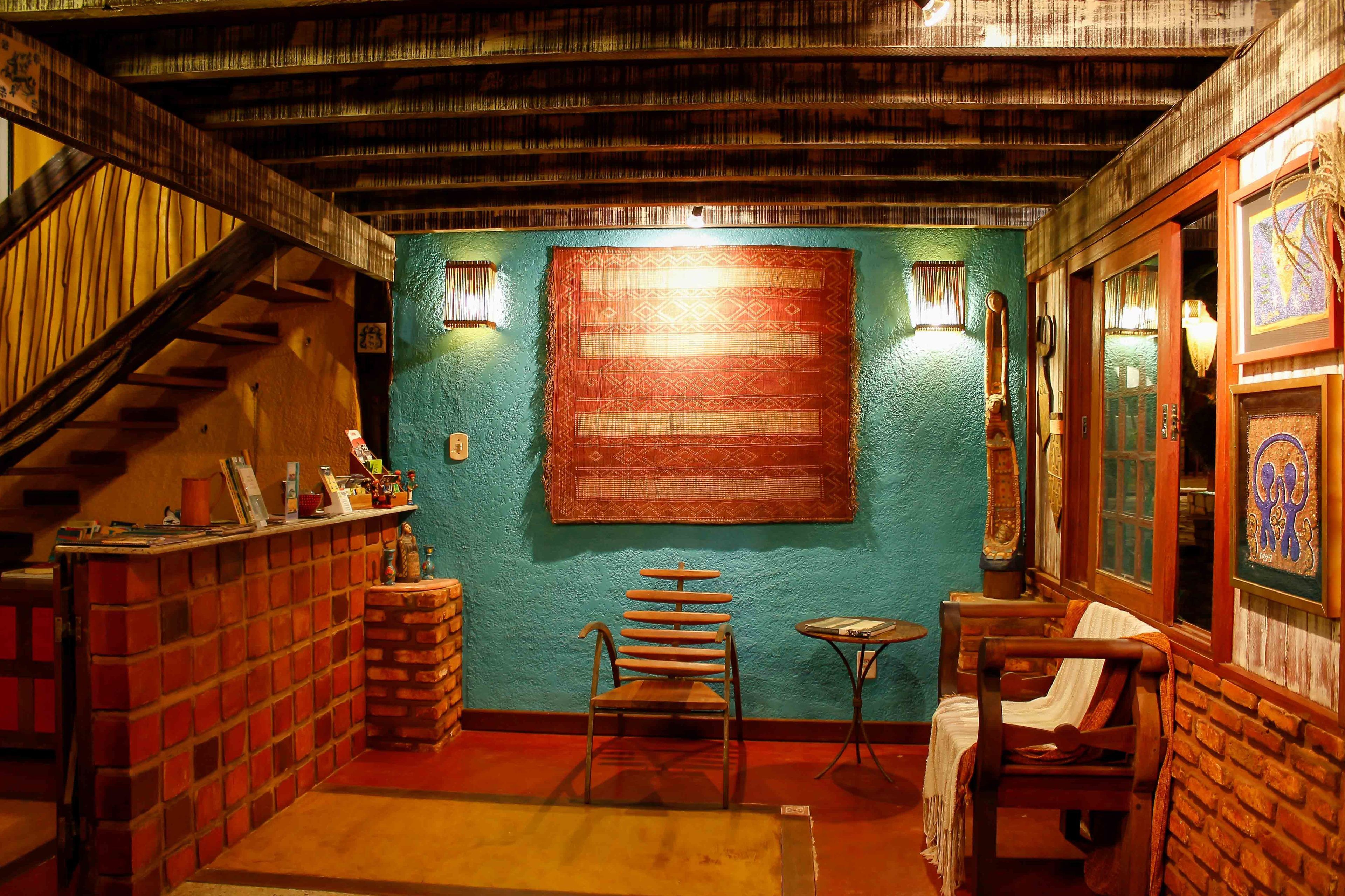 Una habitación acogedora con pared de ladrillo, una silla de madera, una mesita pequeña y una escalera.