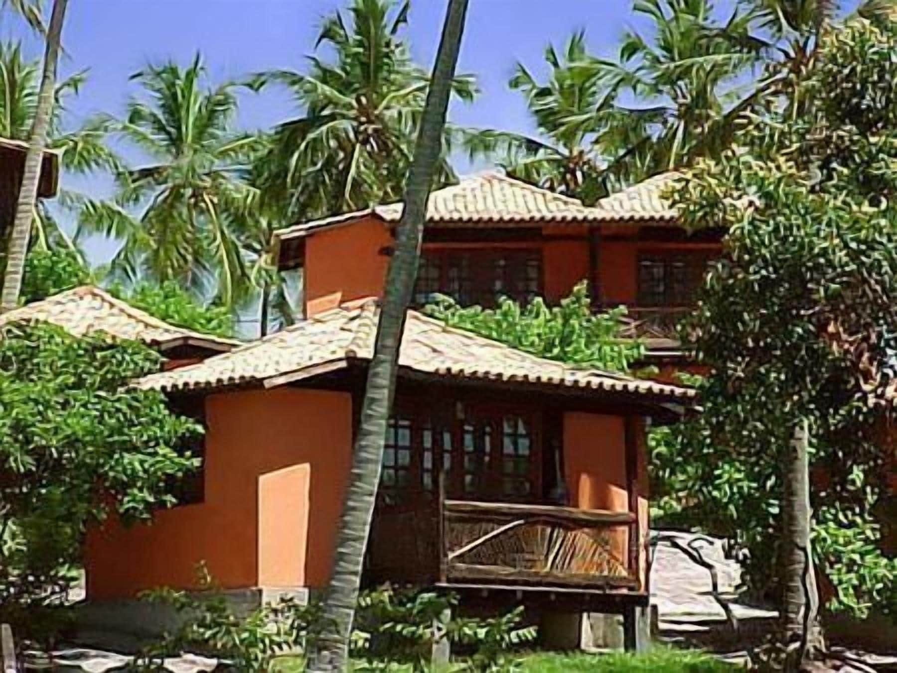 A traditional building with a tiled roof, surrounded by palm trees.