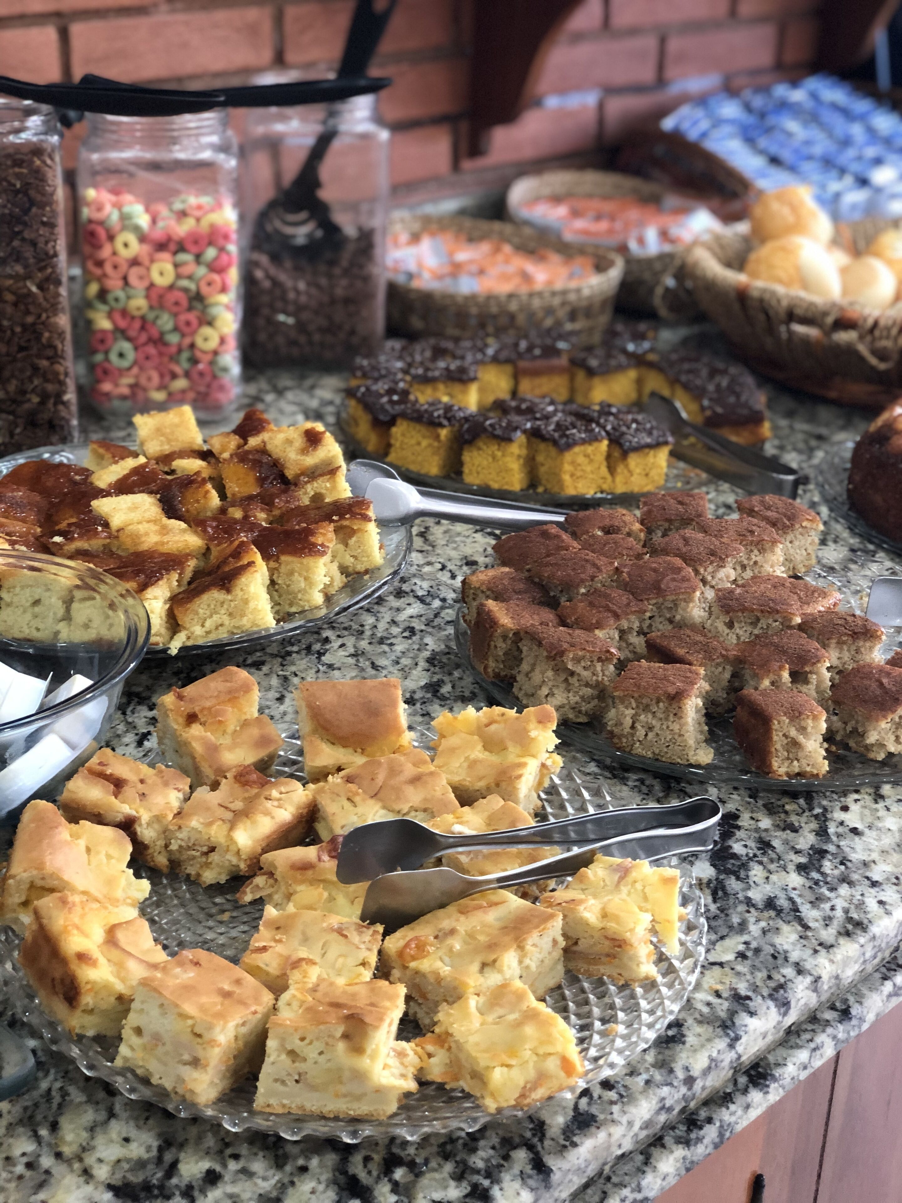 A variety of baked goods on a granite countertop, including cakes and pastries.