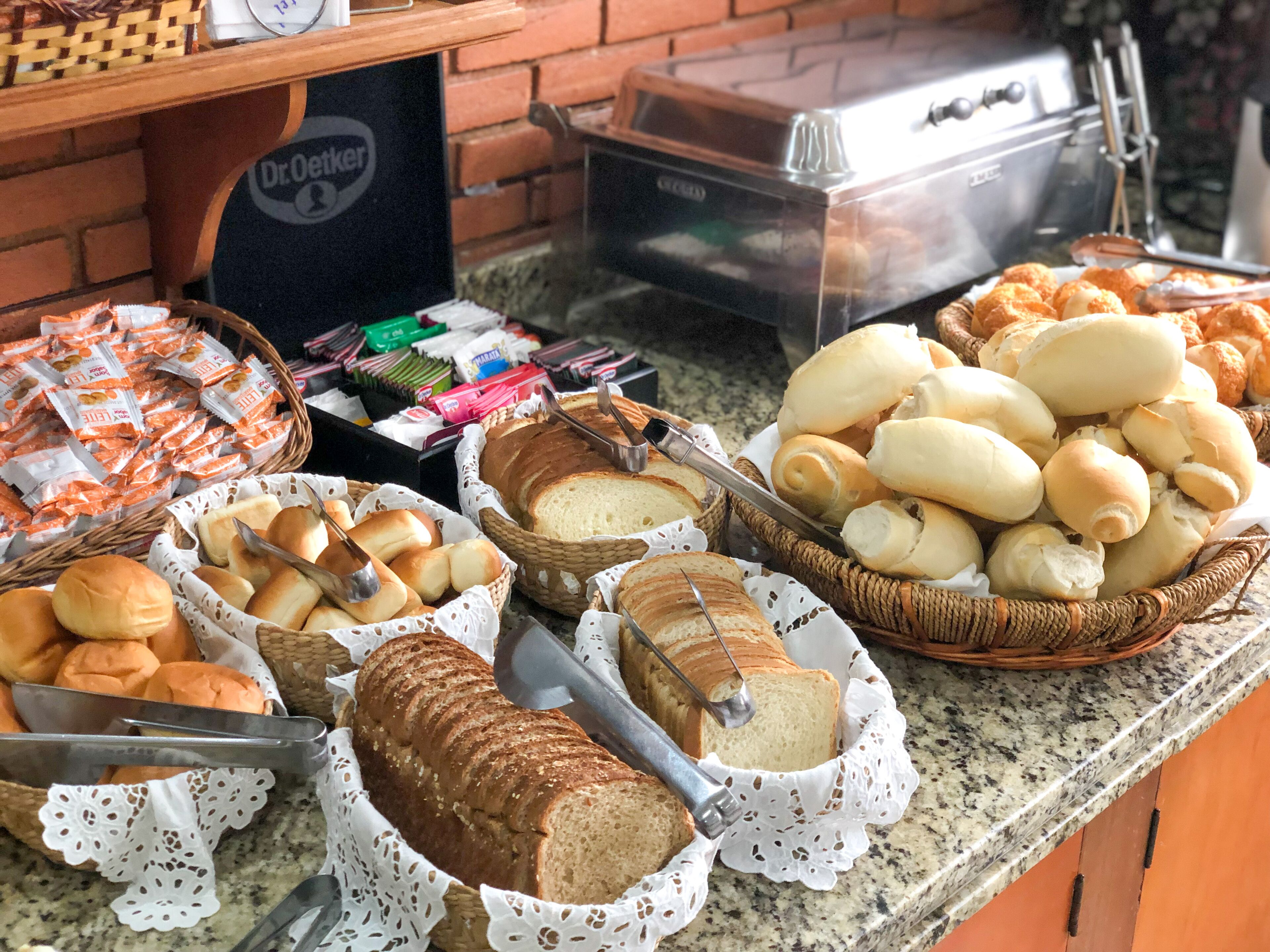 A buffet table with various breads and pastries.
