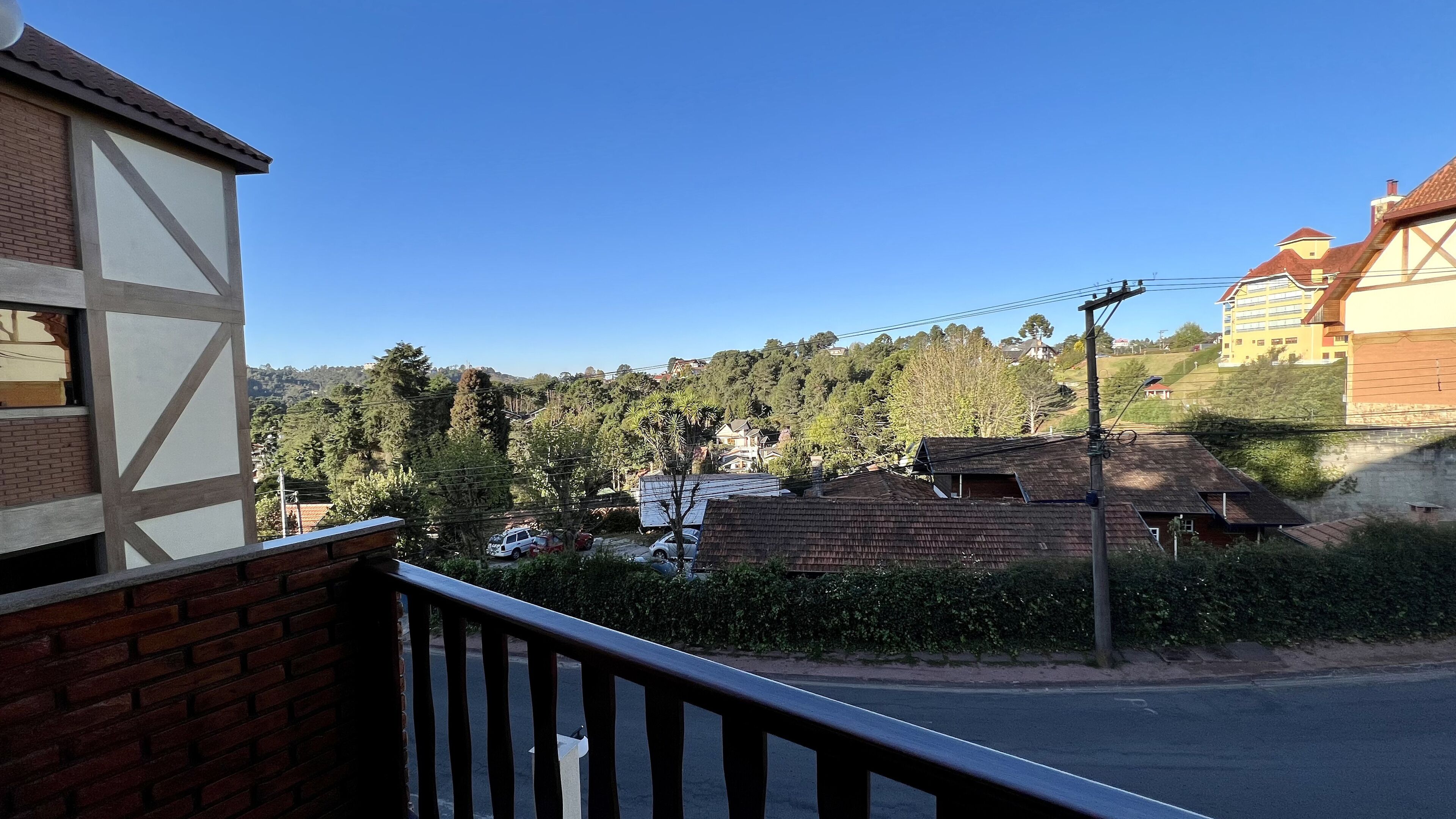 A residential area with houses, a clear sky, and a road.