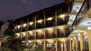 Et hotel med flere etager, en central gårdsplads, altaner og en godt oplyst indgang.