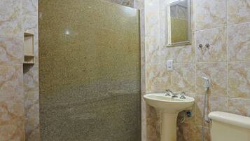 A bathroom with a marble floor, a sink, a toilet, and a shower.