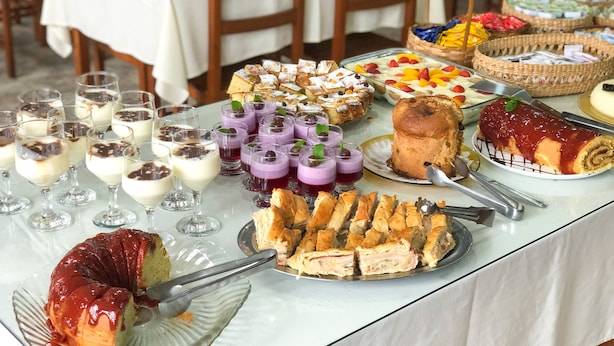 En buffetbord med diverse desserter og kager, herunder kage, tærte og frugttærter.