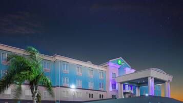A hotel with a modern facade, multiple windows, and a prominent sign for the Holiday Inn Express Suites.