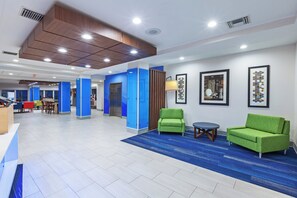 A hotel lobby with a reception desk, seating area, and a blue carpet. - Holiday Inn Express & Suites Port Lavaca by IHG (Port Lavaca)