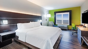 Une chambre d’hôtel moderne dotée d’un grand lit, de tables de chevet, d’un bureau avec une chaise, d’une fenêtre offrant une vue et d’un téléviseur à écran plat.