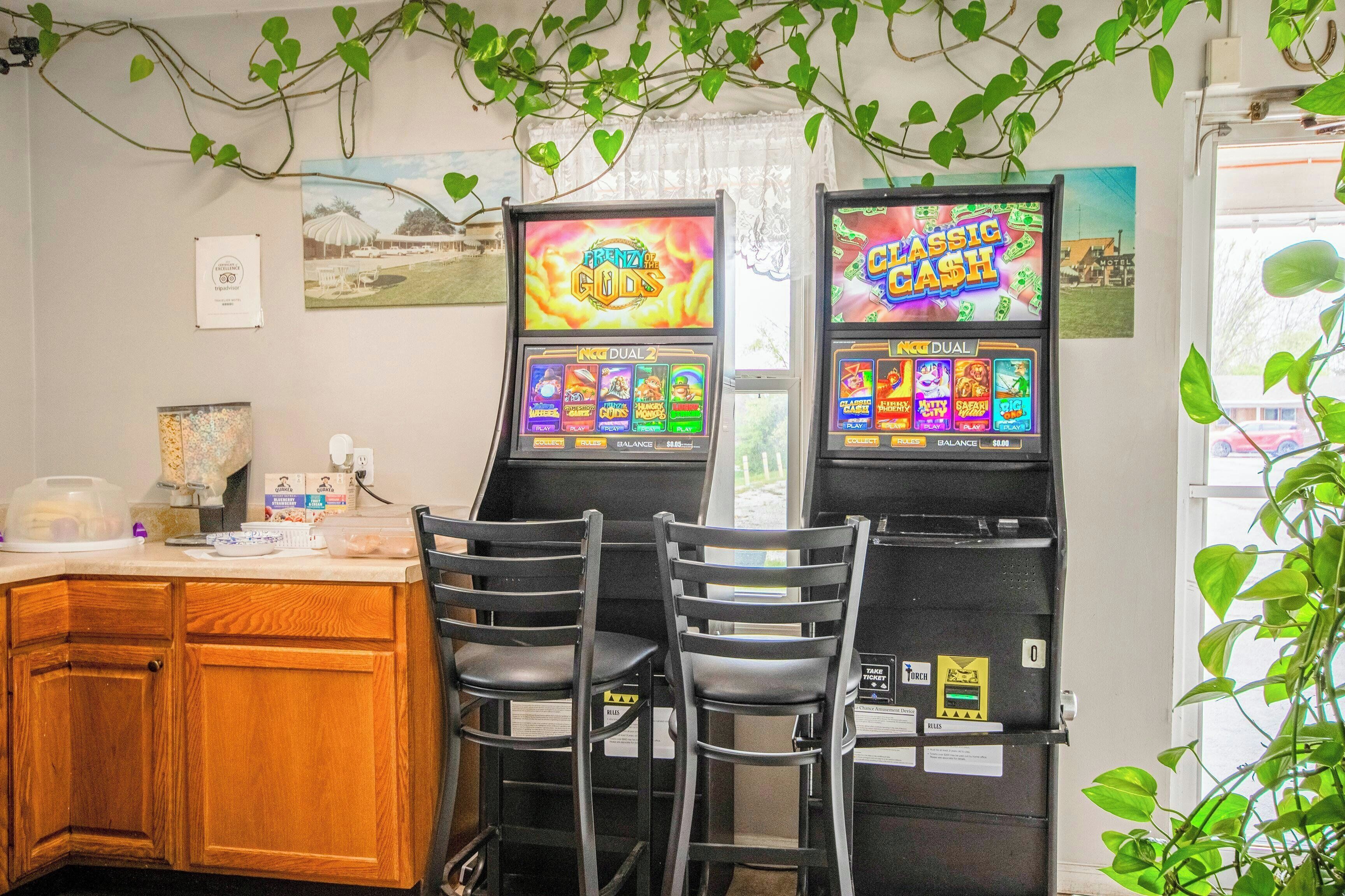 A room with two slot machines, wooden cabinets, and a window with a view.