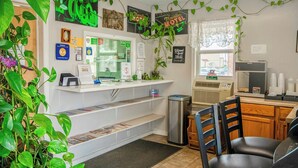 A reception area with a counter, a trash bin, and a seating area with chairs.