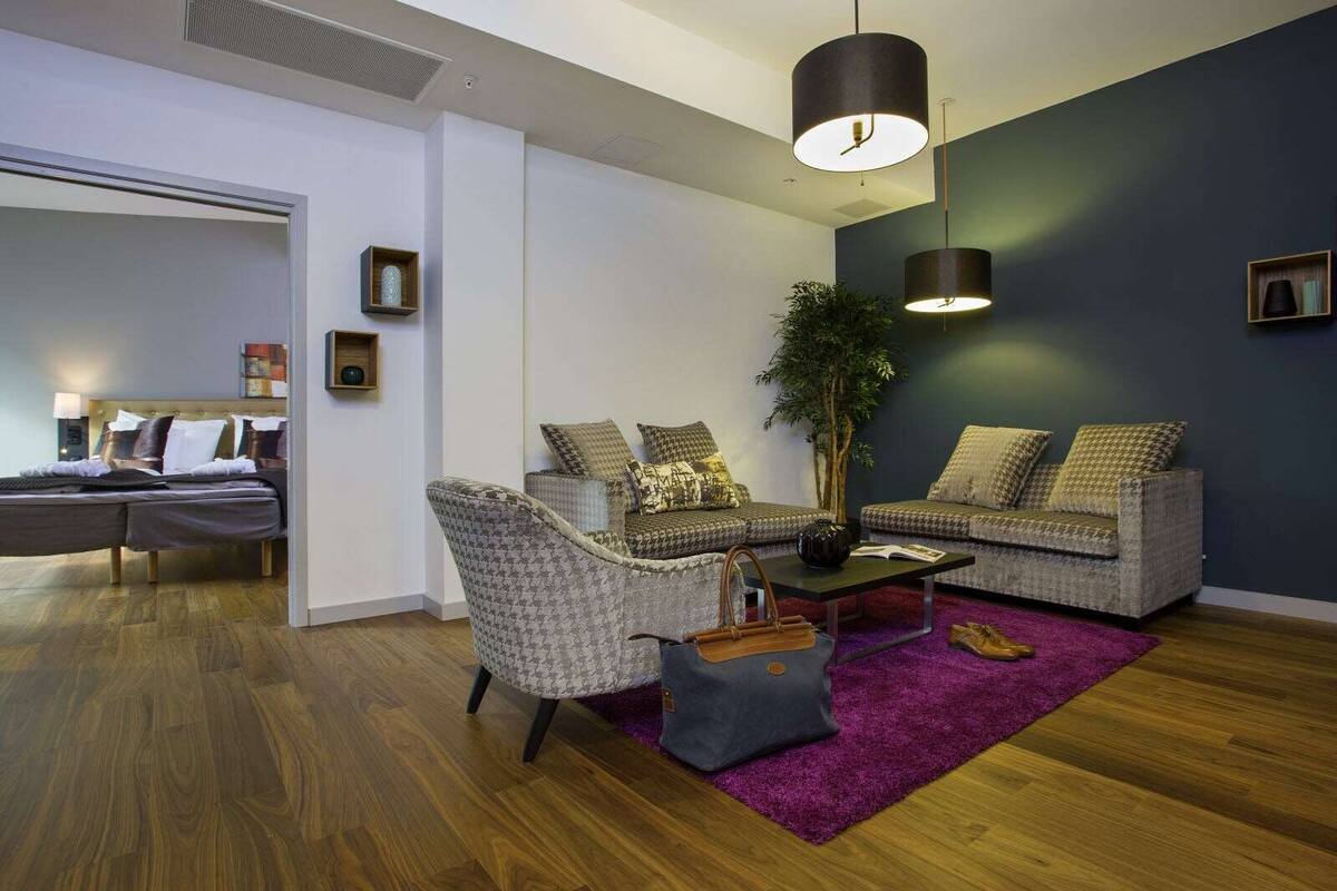 A modern living room with a sofa set, a coffee table, and a large plant.