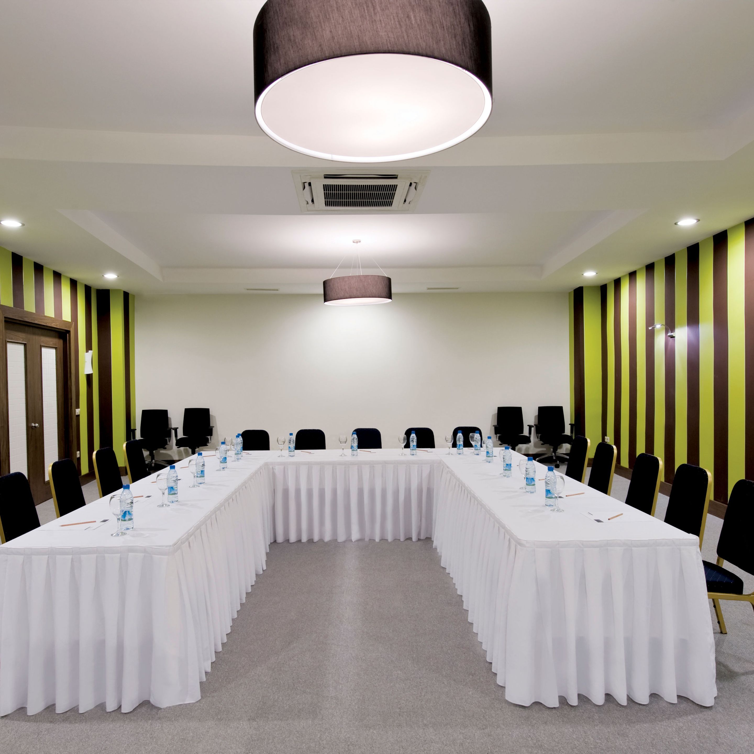 A conference room with a long table, chairs, and water bottles.