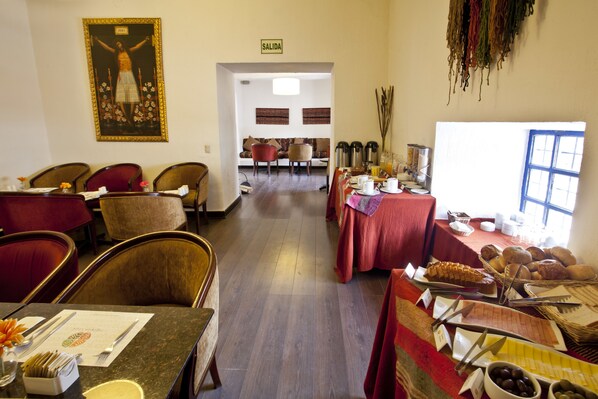 A dining area with multiple tables, chairs, and a buffet with various food items. - Tierra Viva Cusco Saphi (Cusco)