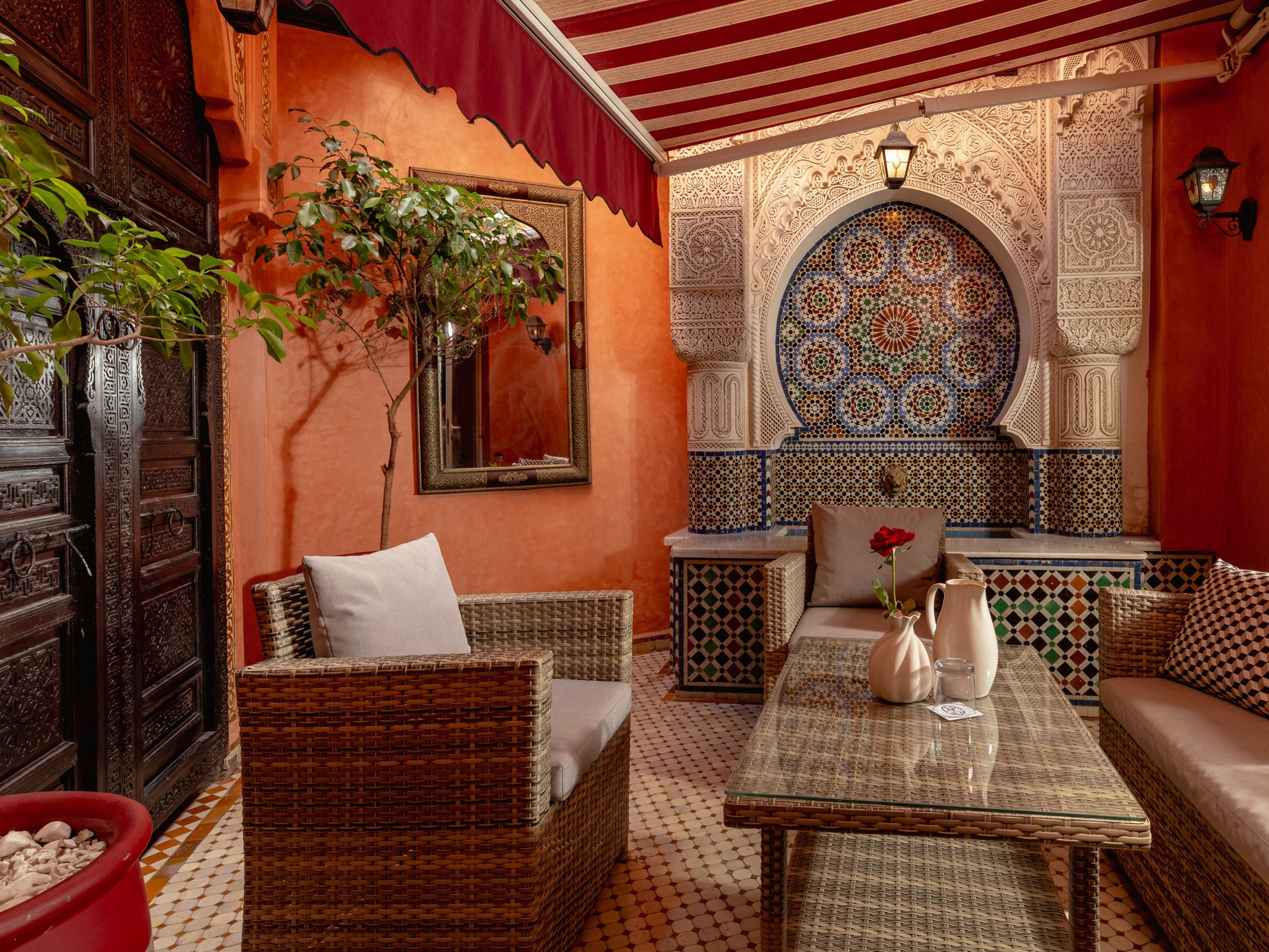 A cozy interior with wicker furniture, a tiled floor, and intricate wall designs.