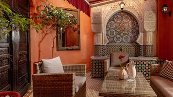 A cozy interior with wicker furniture, a tiled floor, and intricate wall designs.