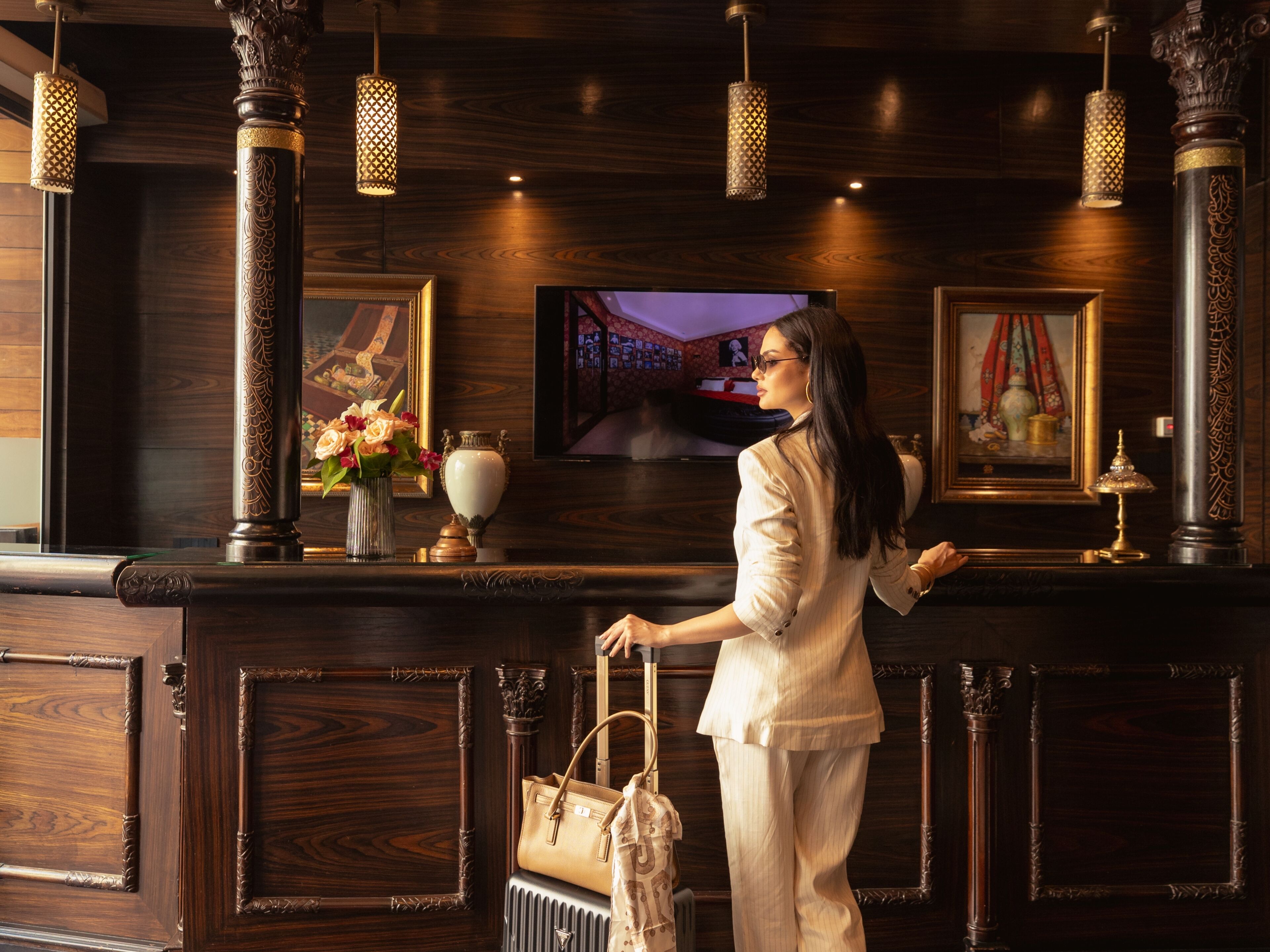A reception desk with a television, framed artwork, and decorative vases.