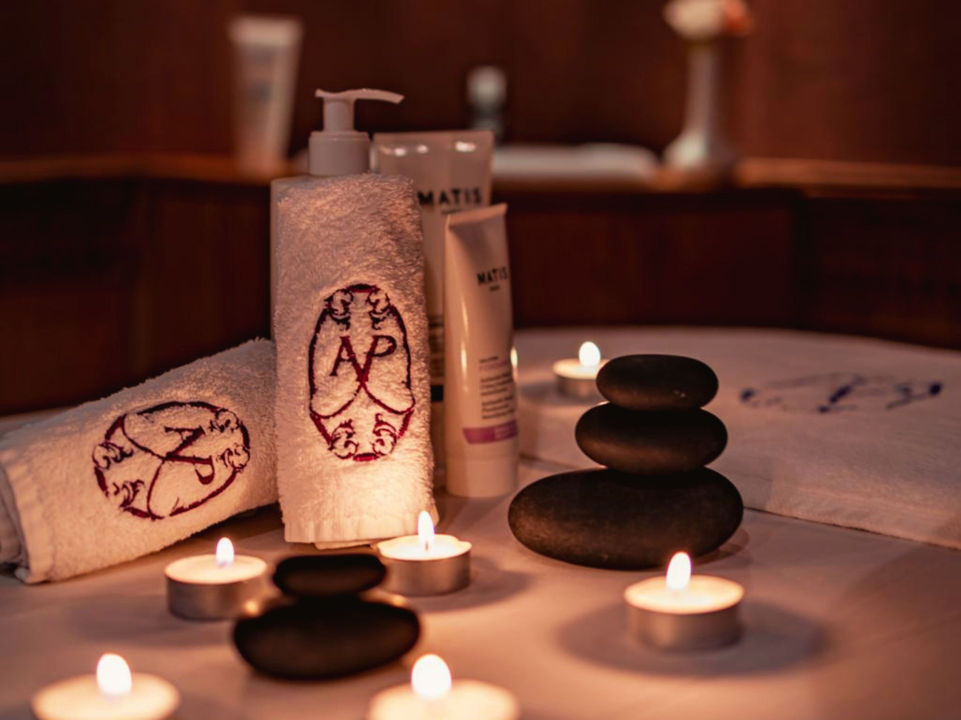 A spa setting with towels, candles, and spa products.