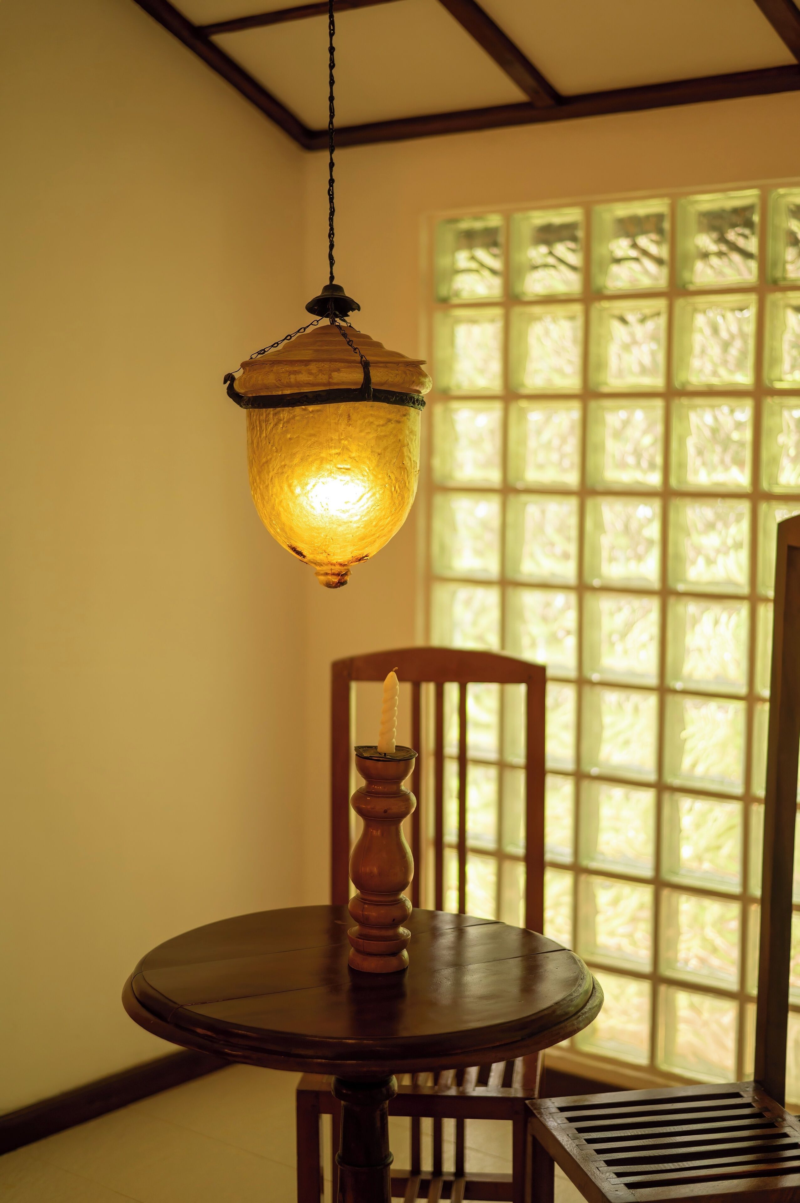 A traditional Japanese room with tatami flooring, a wooden table with a candle, and a shoji screen window.