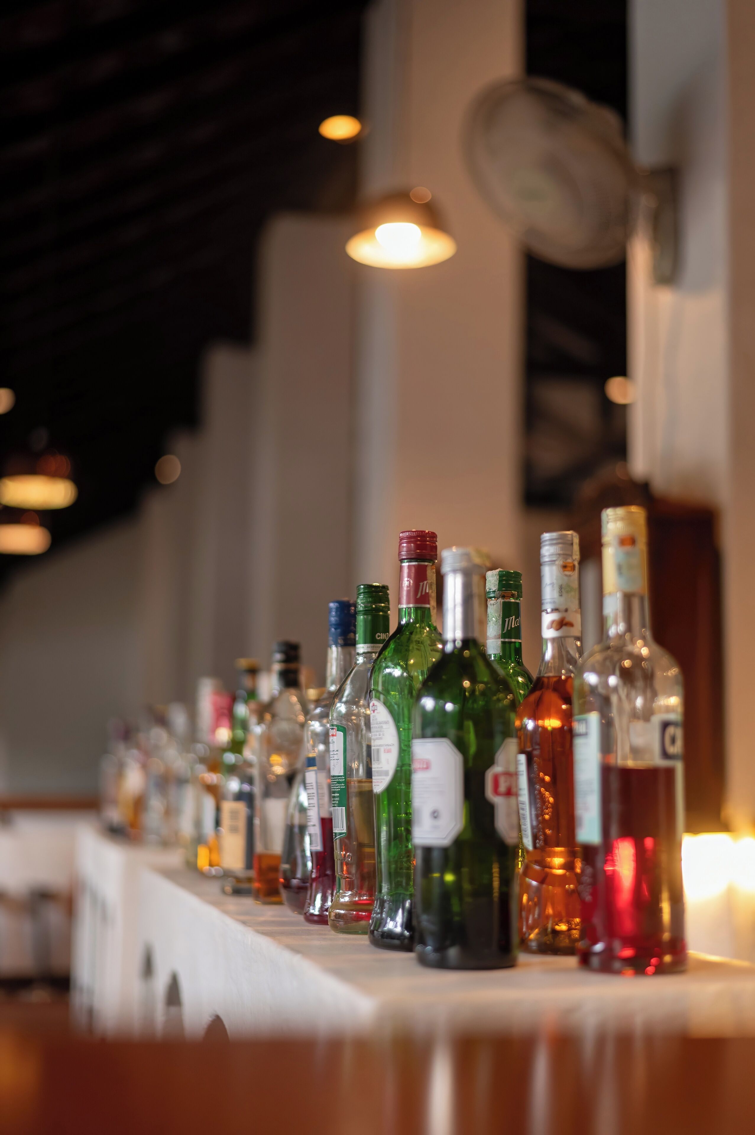 A bar with a variety of liquor bottles lined up on a counter.