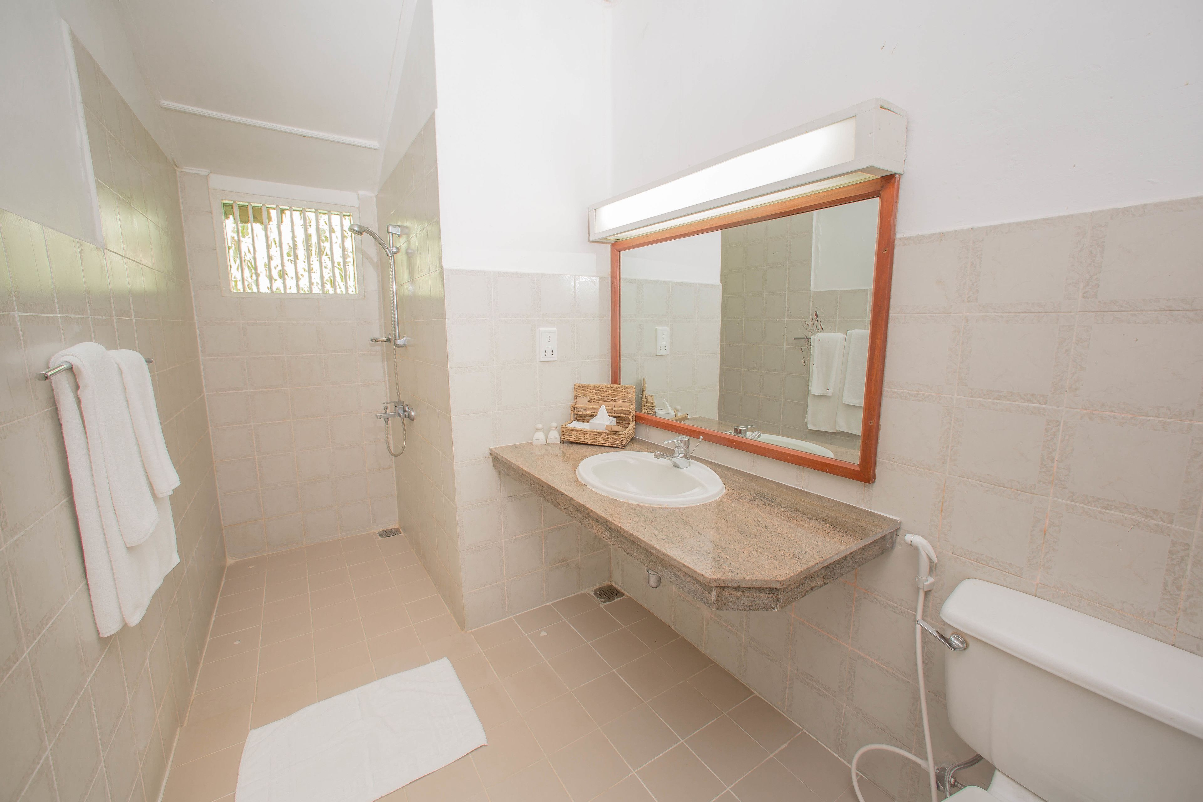A bathroom with a shower, sink, and toilet.