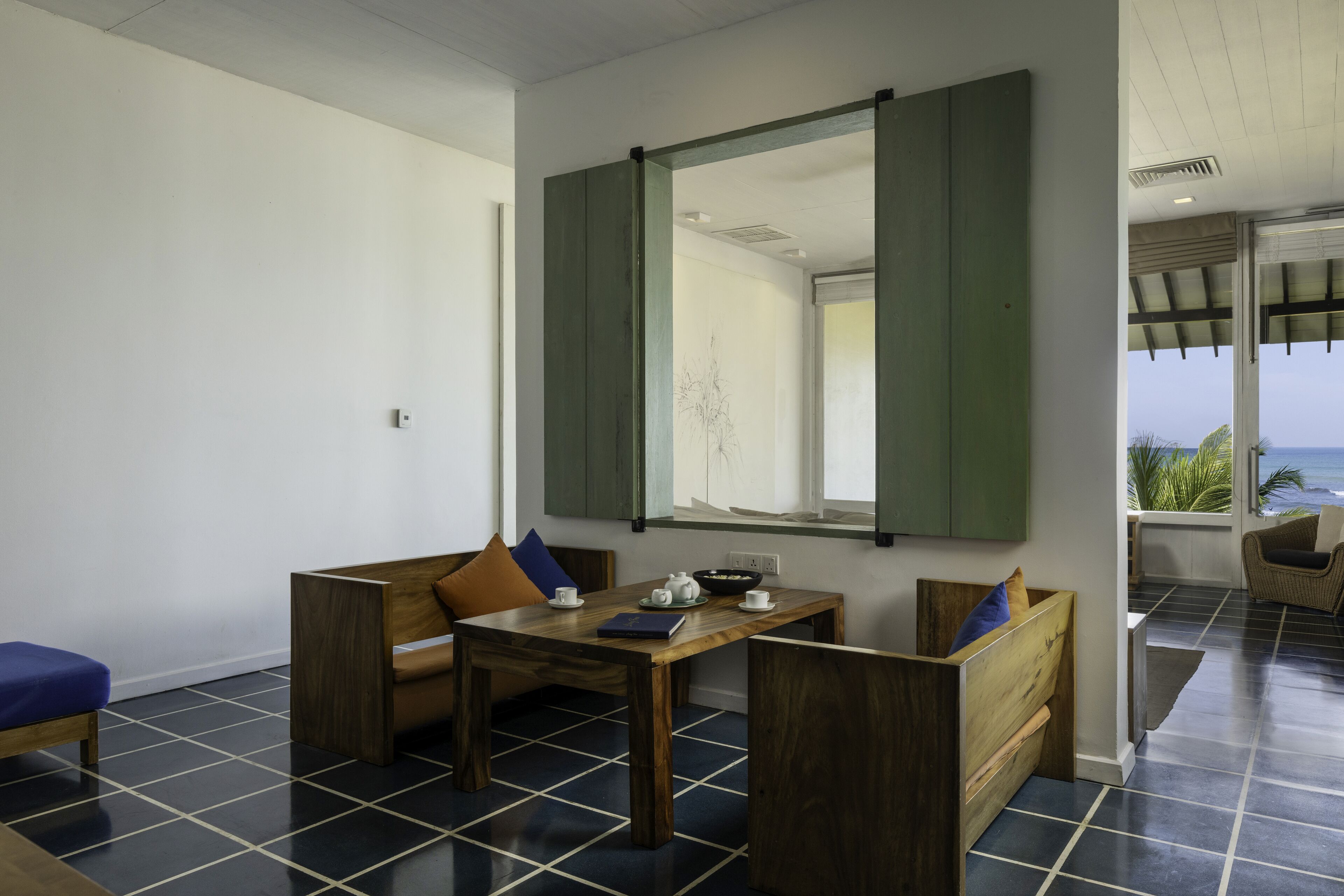 A modern room with a wooden table, two wooden benches, and a large mirror.