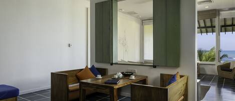 Una habitación moderna con una mesa de madera, dos bancos de madera y un espejo grande.