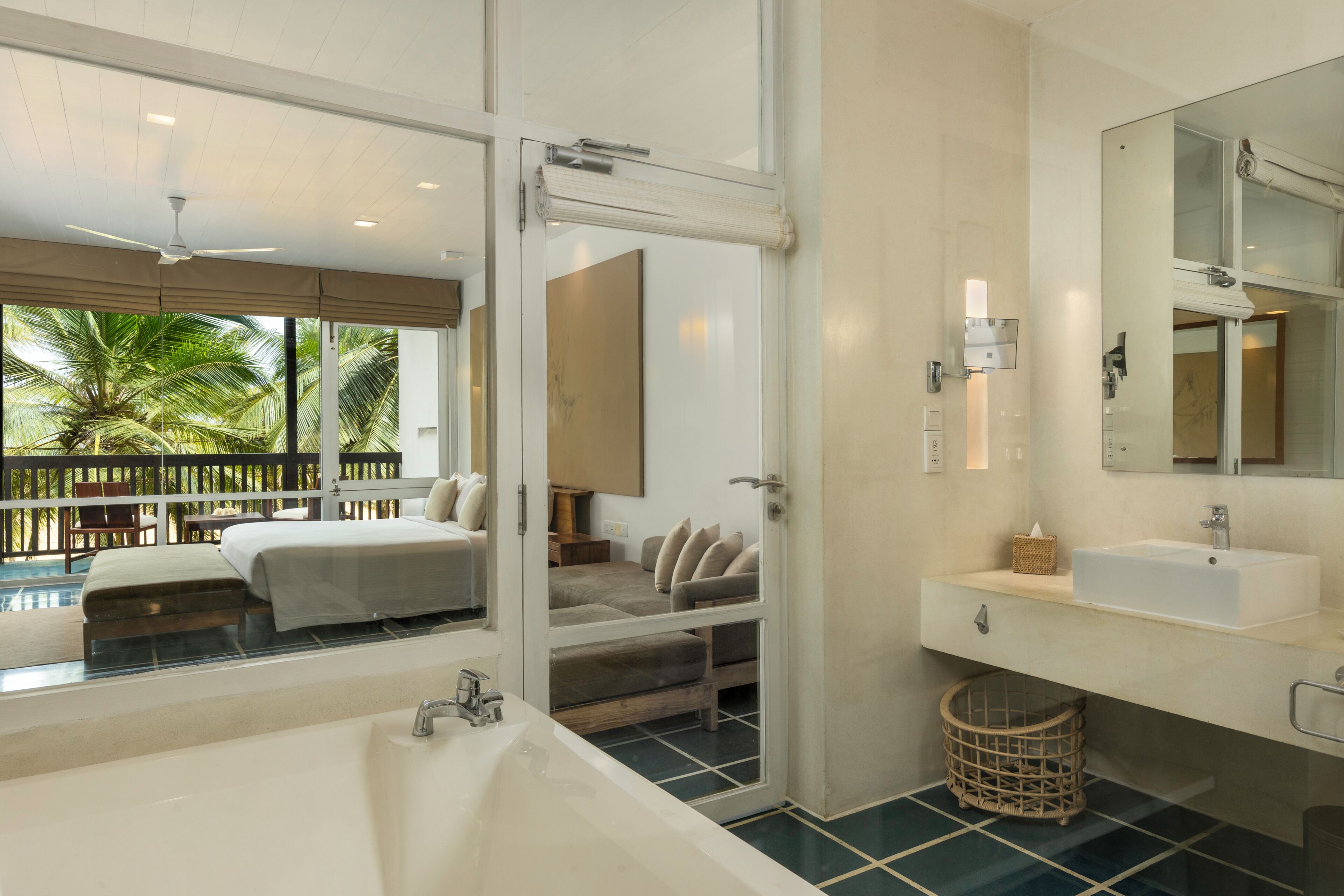 A modern bathroom with a large bathtub, a sink, and a mirror.