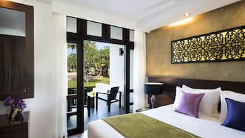 Una habitación de hotel con cama, mesita de noche, lámpara y vistas al exterior.