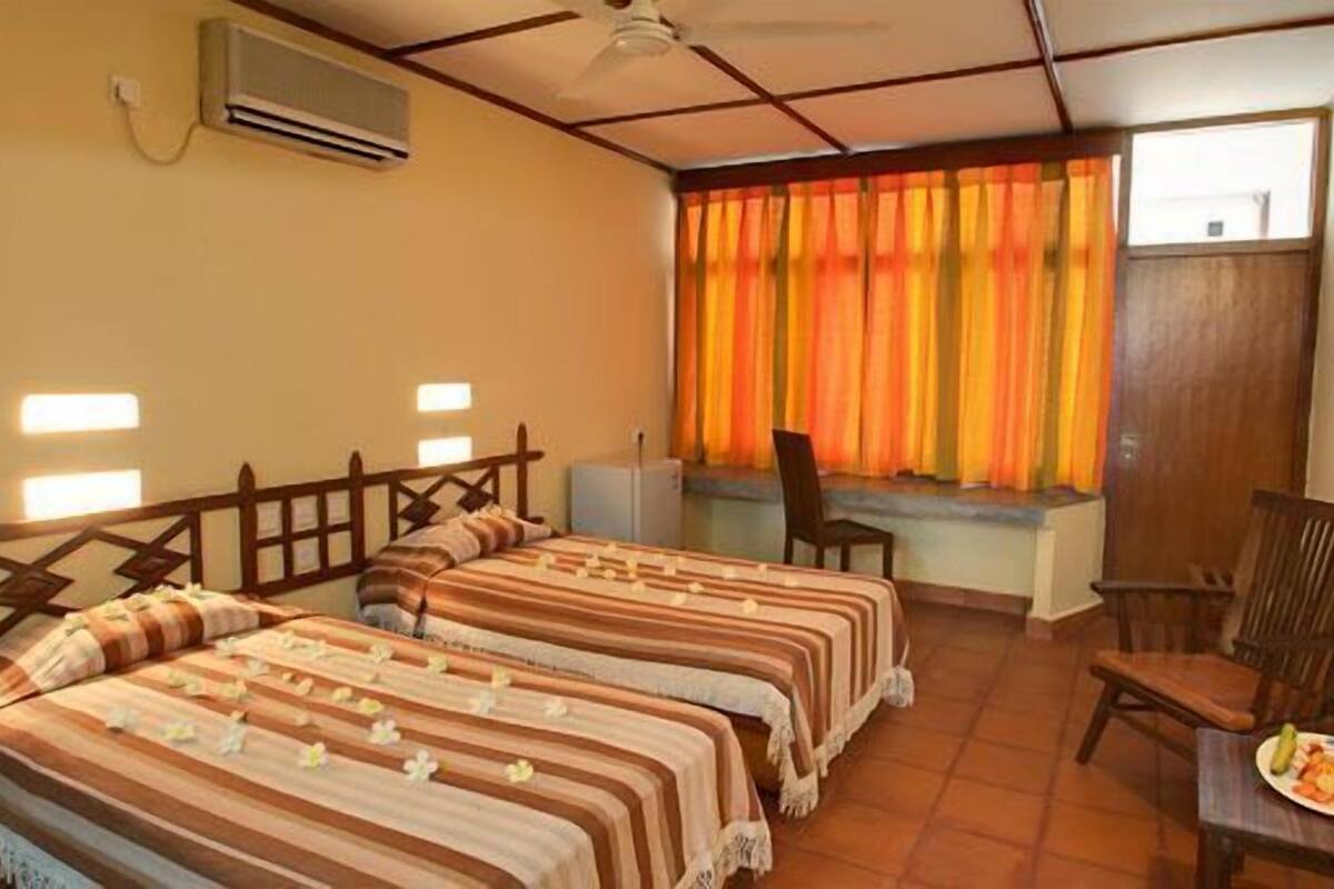 A room with two beds, a desk, and a chair.
