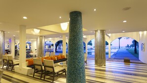 A spacious lobby with a central seating area, large pillars, and a view of the beach through arched openings. - Trinco Blu by Cinnamon (Trincomalee)