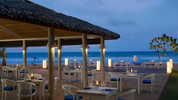 An outdoor dining area with tables and chairs, overlooking the ocean. - Trinco Blu by Cinnamon (Trincomalee)