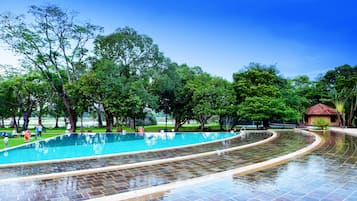 Alberca al aire libre, sombrillas en la alberca y camastros