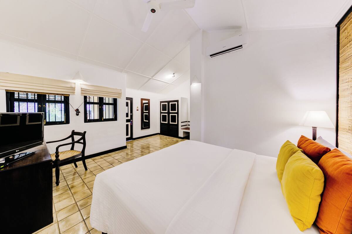 Une chambre d’hôtel équipée d’un lit, d’un bureau, d’une chaise et d’un téléviseur.