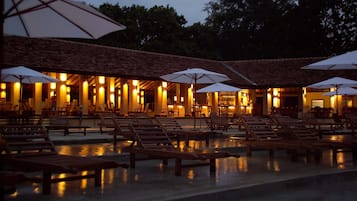 Una piscina al aire libre, sombrillas, tumbonas