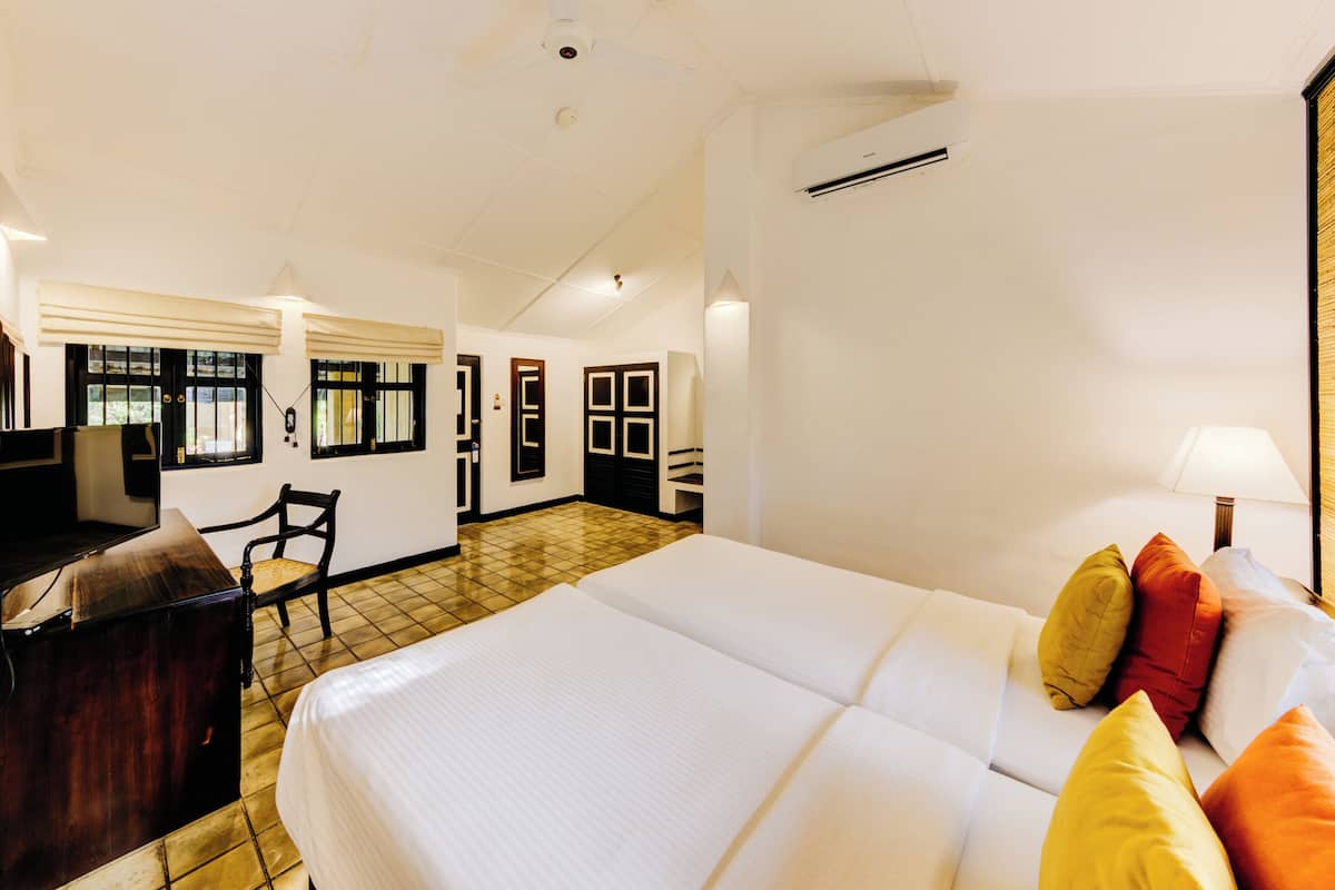 Une chambre d’hôtel avec un lit, un bureau, une chaise et une fenêtre.