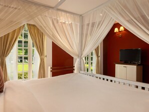 A bedroom with a large bed, a television on a cabinet, and a window with curtains. - Jetwing St. Andrew's (Nuwara Eliya)