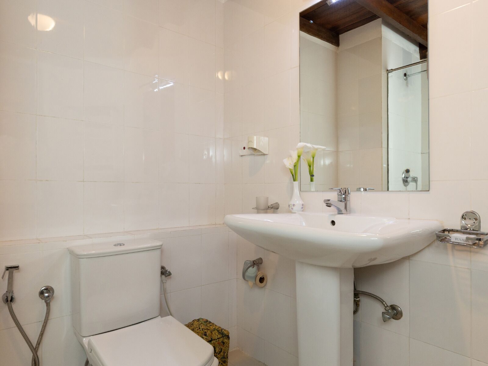 Un baño con inodoro, lavamanos, ducha y espejo.