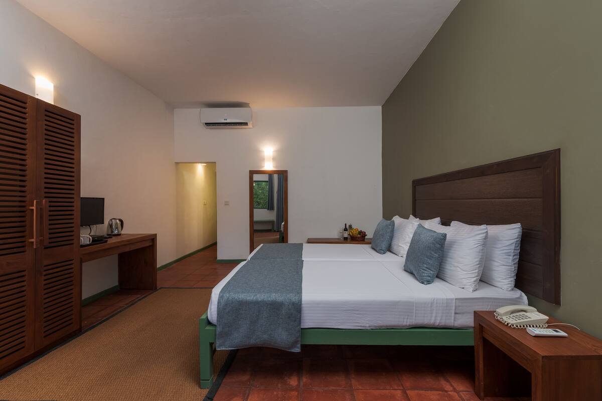 A bedroom with a bed, bedside table, and a wardrobe.