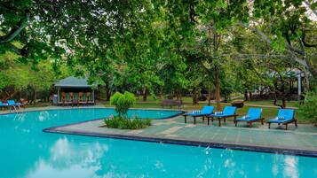 Una piscina al aire libre, sombrillas, tumbonas