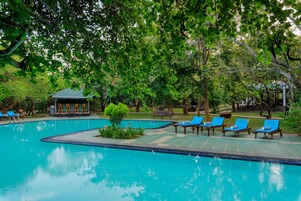 Una piscina al aire libre, sombrillas, tumbonas