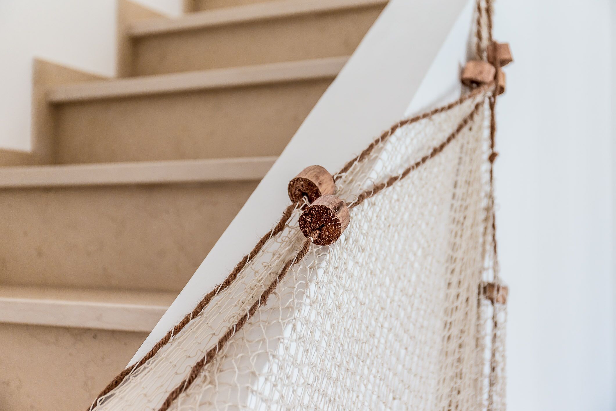 Una escalera con barandilla blanca y una estructura de red.