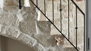 Una escalera de piedra con barandilla de metal negro.