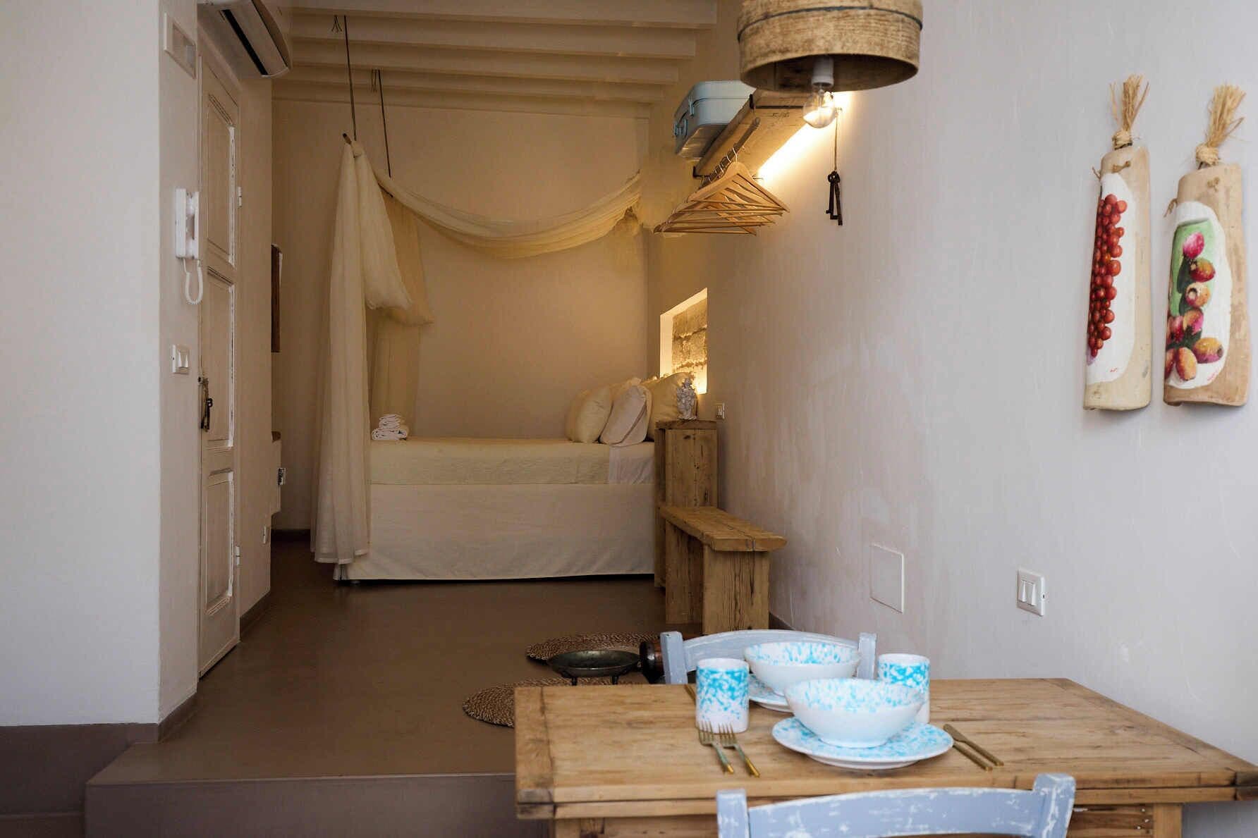 Un dormitorio acogedor con cama, mesita de noche y lámpara colgante.