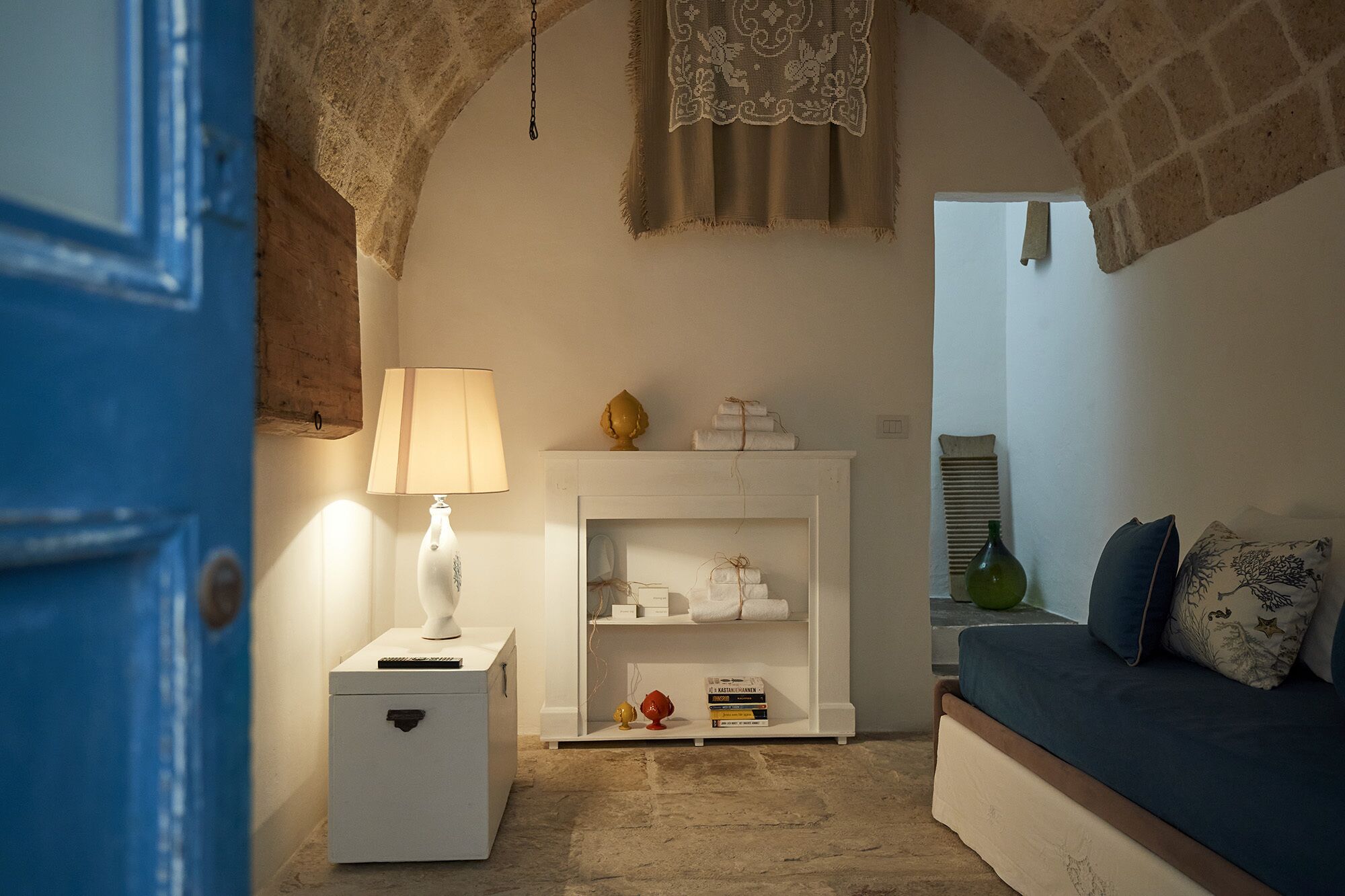 A cozy room with a white fireplace, a blue door, and a blue sofa.