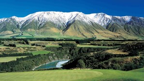 A golf course with a mountain backdrop.