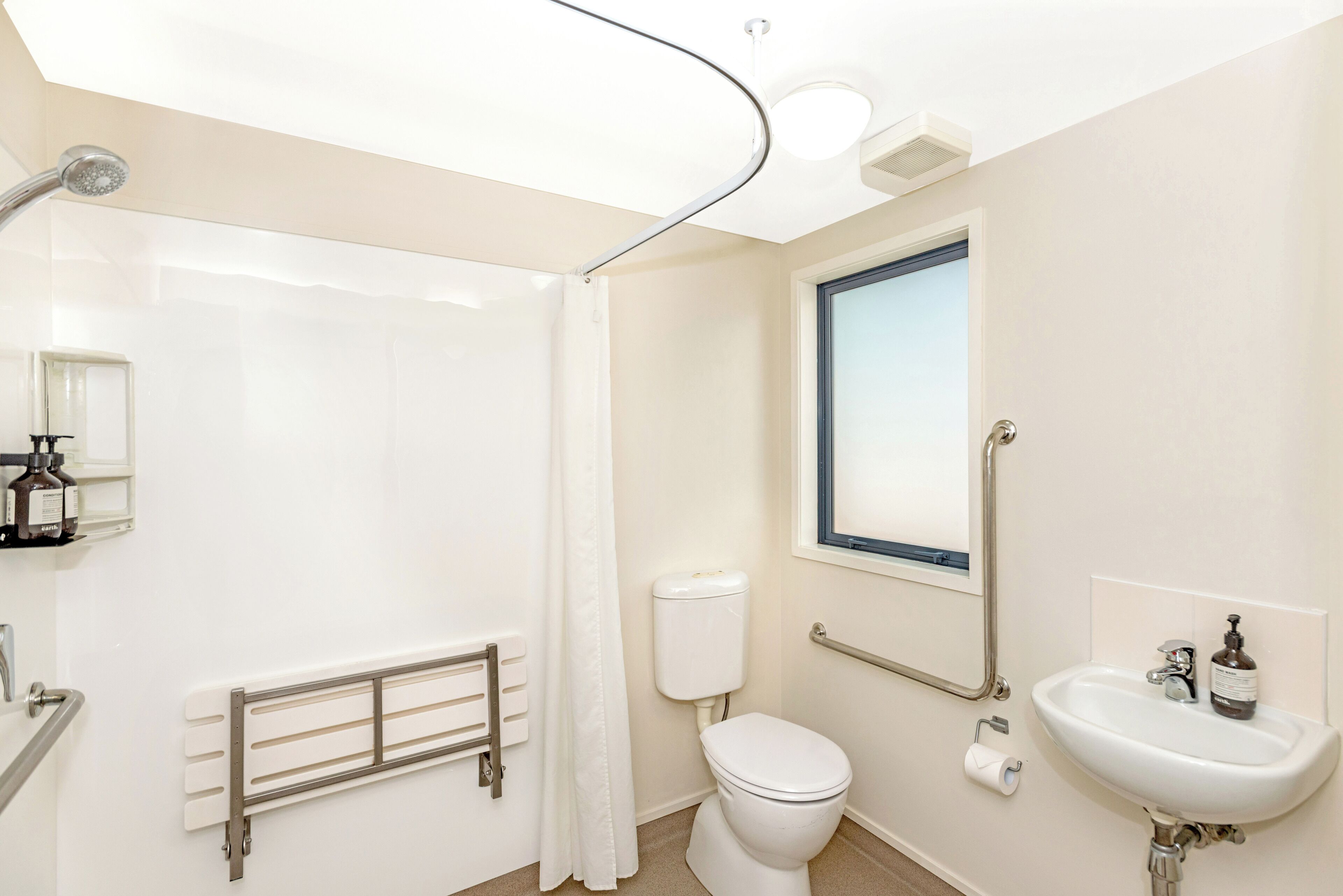 A modern bathroom with a shower, toilet, and sink.