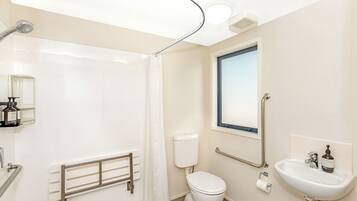 A modern bathroom with a shower, toilet, and sink.