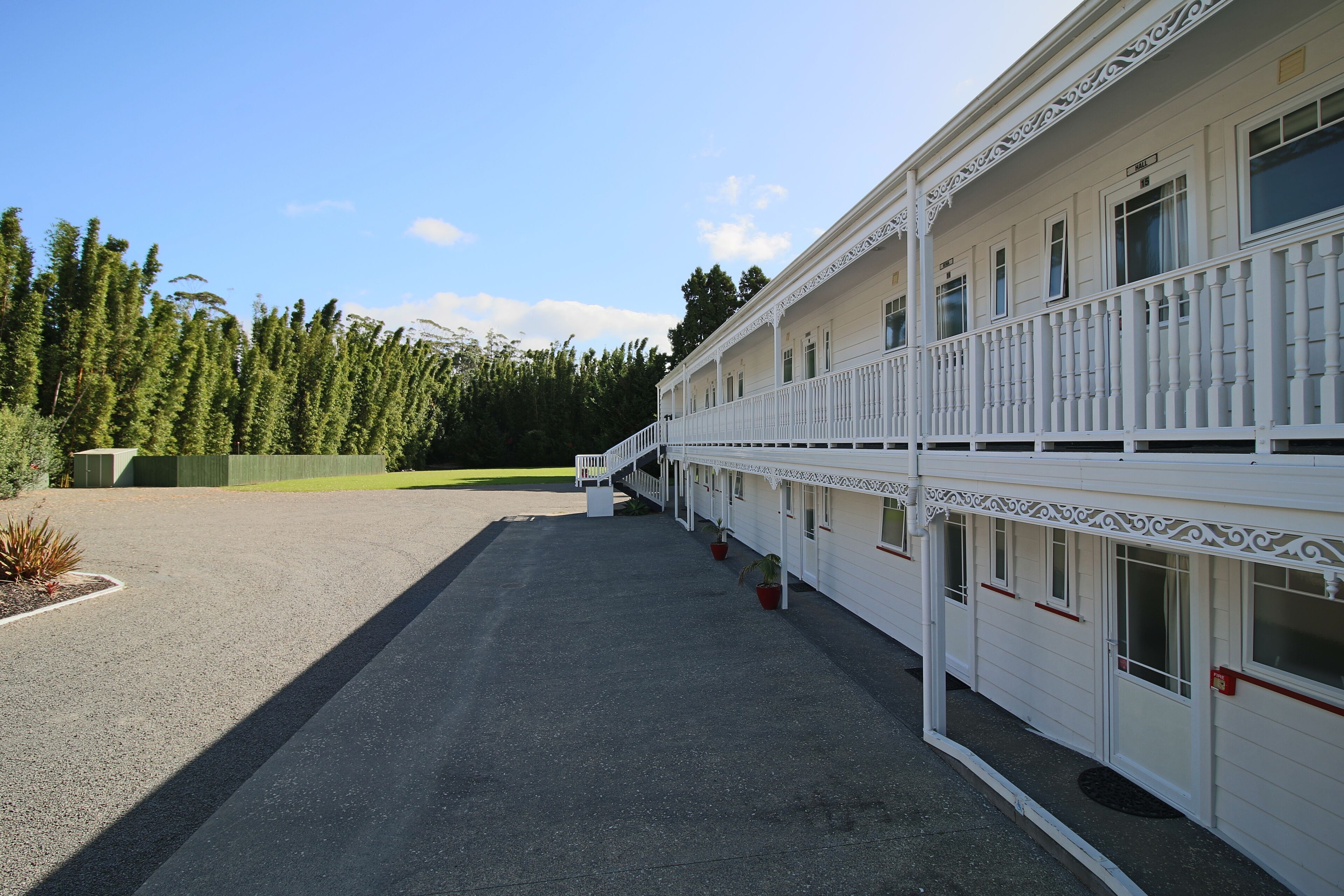 A white building with a covered walkway and multiple windows.