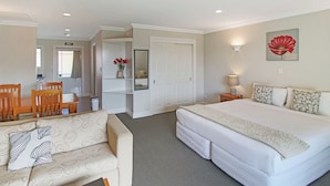 Una habitación de hotel con cama, sofá, zona de comedor y baño.