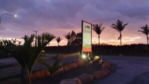 Señal de Keriaki Park Lodge con vista a palmeras y un cielo al atardecer.